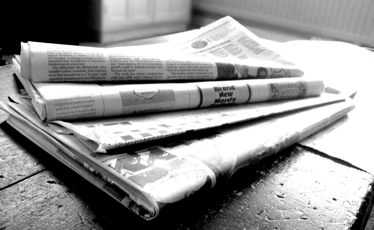 Black-and-white image of stacked newspapers