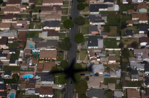 The shadow of an United Airlines plane is seen over a Los Angeles neighborhood on February 20, 2013. The soft focus on the top part of the photo is caused by gases released by the plane engine. Picture taken on February 20.   REUTERS/Adrees Latif  (UNITED STATES - Tags: TRANSPORT)