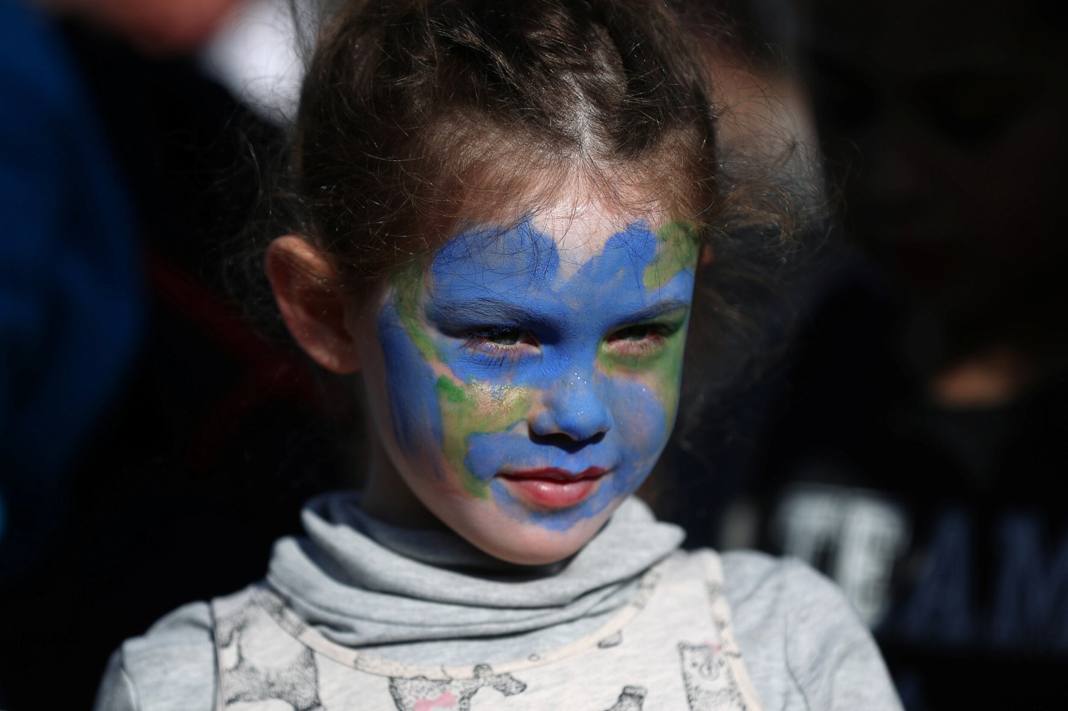 A girl looks on as people take part in a "youth strike for climate change" demonstration in London, Britain February 15, 2019. REUTERS/Simon Dawson - RC1F44A5E6F0