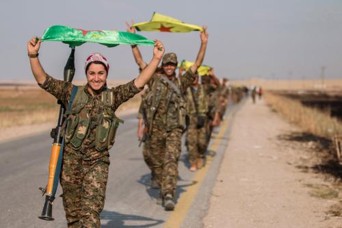 Kurdish fighters gesture while carrying their parties' flags in Tel Abyad of Raqqa governorate after they said they took control of the area June 15, 2015. Syrian Kurdish-led forces said they had captured a town at the Turkish border from Islamic State on Monday, driving it away from the frontier in an advance backed by U.S.-led air strikes that has thrust deep into the jihadists' Syria stronghold. The capture of Tel Abyad by the Kurdish YPG and smaller Syrian rebel groups means the Syrian Kurds effectively control some 400 km (250 miles) of the Syrian-Turkish border that has been a conduit for foreign fighters joining Islamic State. Picture taken June 15, 2015. REUTERS/Rodi Said TPX IMAGES OF THE DAY      - GF10000129146