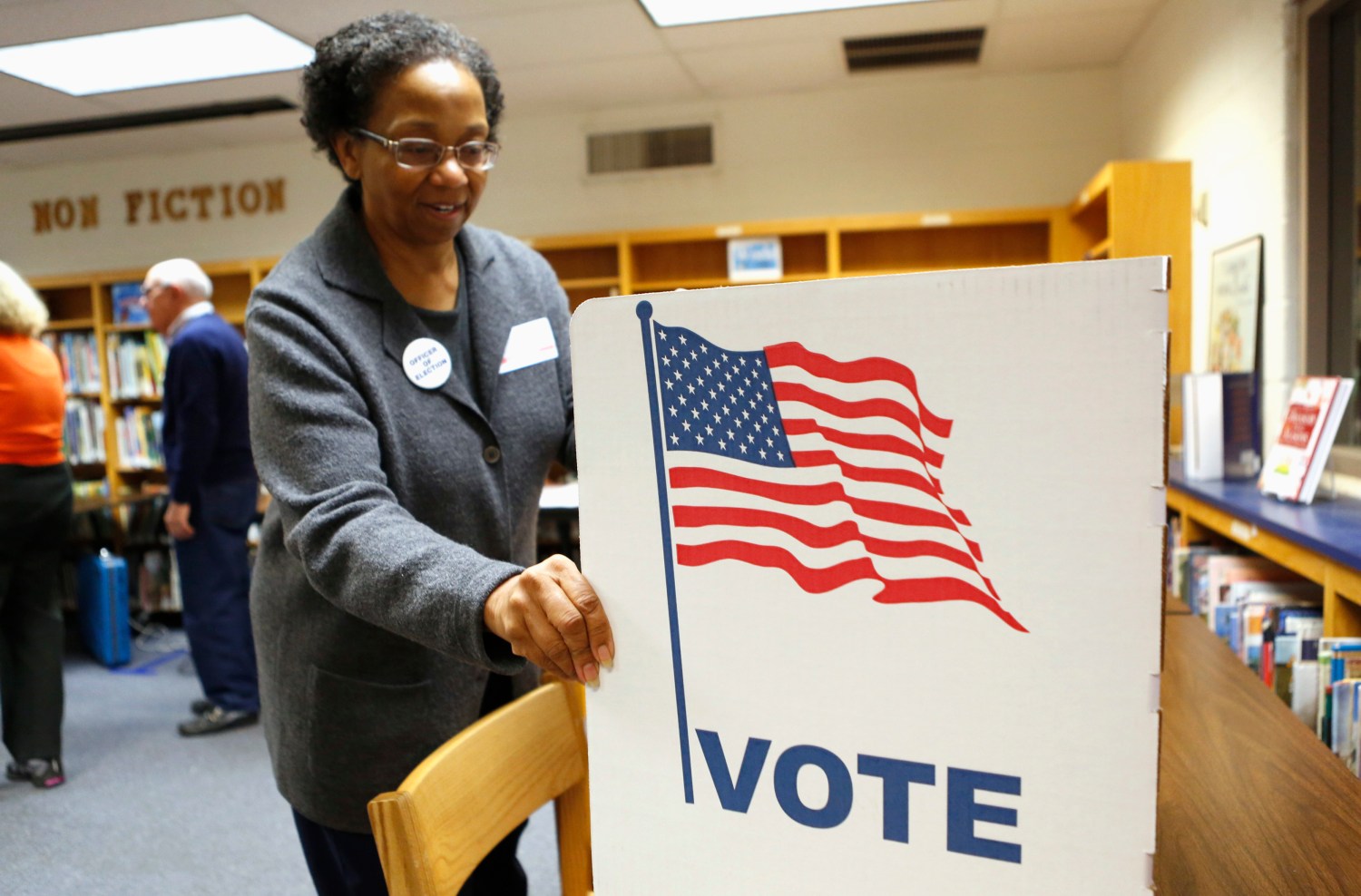 An election worker sets up a voting booth in the library of Spring Hill Elementary School, which is being used as a polling station in McLean, Virginia November 5, 2013. REUTERS/Kevin Lamarque (UNITED STATES - Tags: POLITICS ELECTIONS) - GM1E9B51PZY01