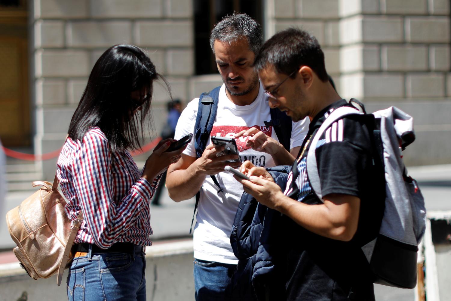 People look at their smartphones in lower Manhattan in New York City, U.S., May 8, 2019. REUTERS/Mike Segar - RC1AD90F8460