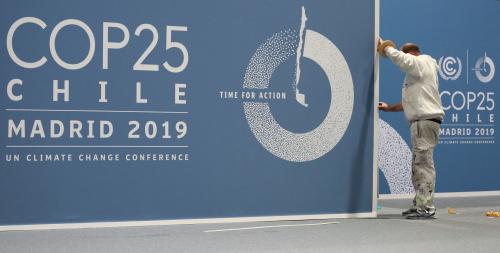 A worker adjusts a banner at IFEMA Convention Center ahead of the 2019 U.N. climate change conference (COP 25) in Madrid, Spain, November 30, 2019. REUTERS/Sergio Perez - RC2OLD9FBG5P