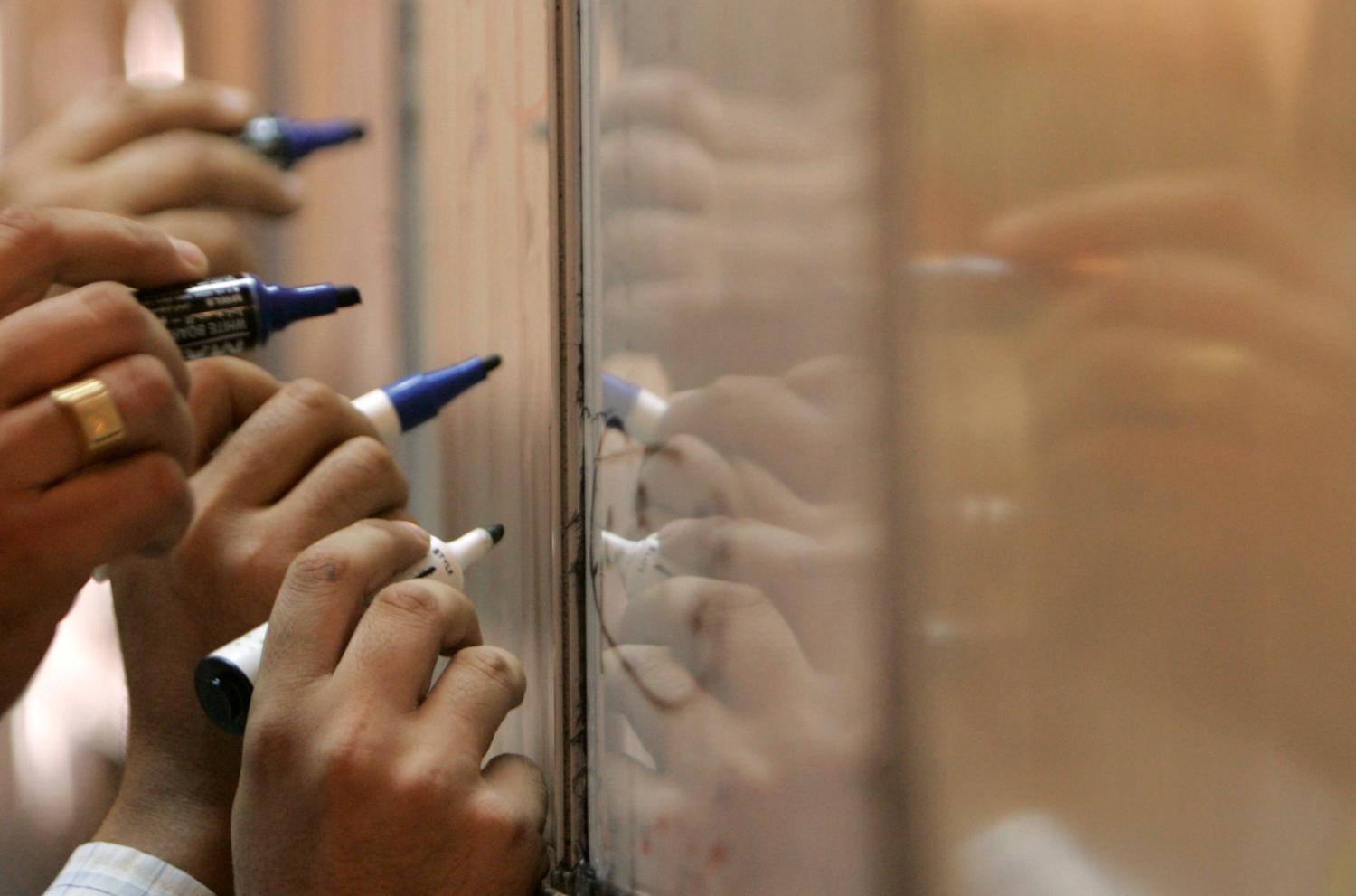 Traders update prices at the Iraq Stock Exchange in Baghdad September 18,2008. REUTERS/Ceerwan Aziz  (IRAQ) - GM1E49I1L8S01