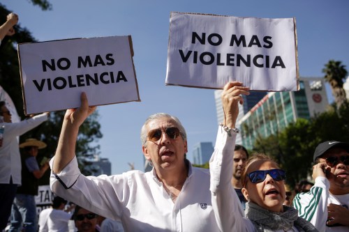Demonstrators hold up signs during a march to protest against violence on the first anniversary of President Andres Manuel Lopez Obrador taking office, in Mexico City, Mexico December 1, 2019. Signs read: "No more violence". REUTERS/Jose Luis Gonzalez - RC2IMD9B6IC5