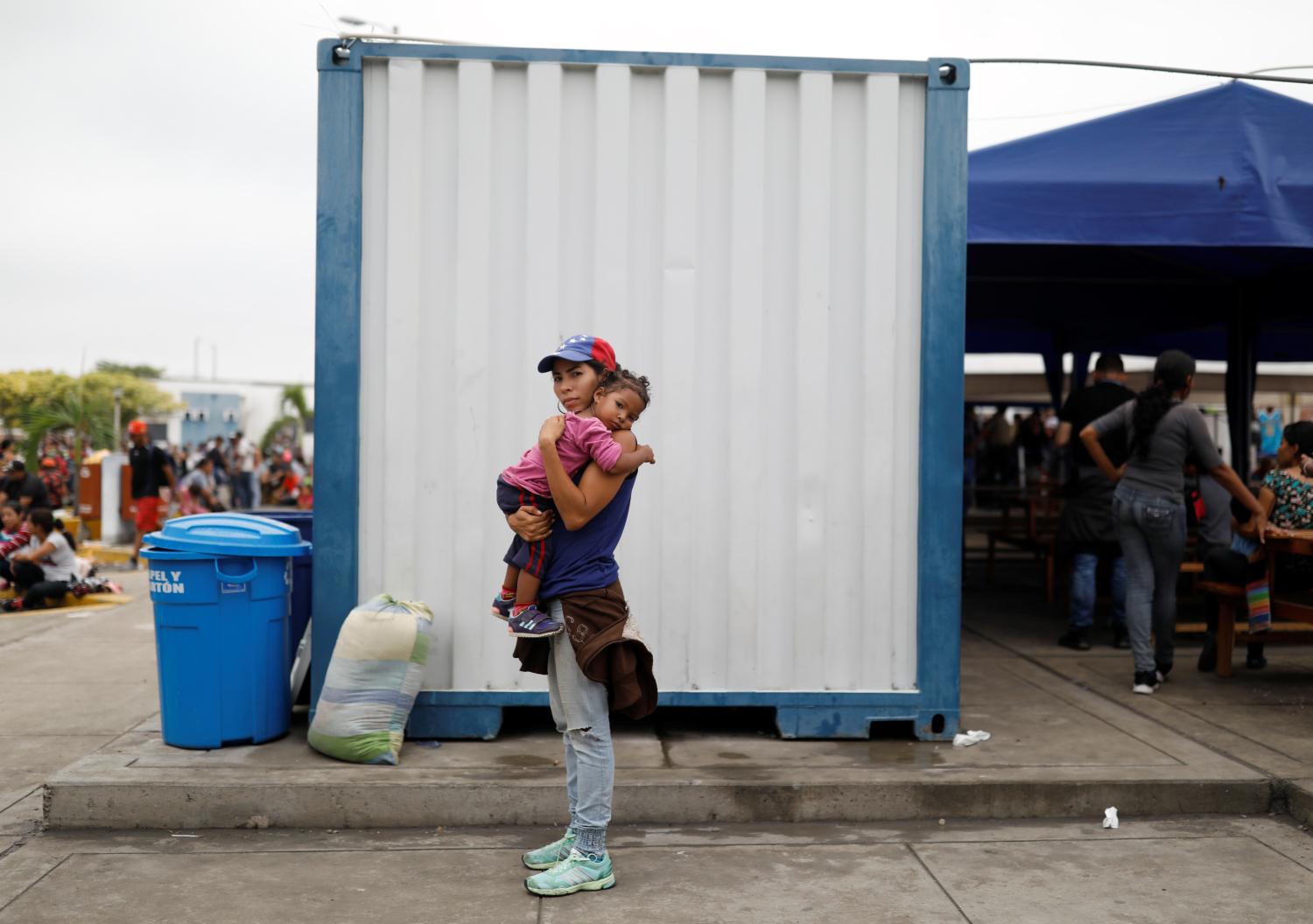 Venezuelan migrant Andraimi Laya, 22, poses for a picture carrying her daughter Jessy, while they wait to process their documents at the Ecuadorian-Peruvian border service centre, before they continue their journey, on the outskirts of Tumbes, Peru, June 16, 2019.  "I really was betting on Guaido. I was sure he was going to change the country," said Andraimi Laya, 22, her 2-year-old wiggling in her arms. When Peru's President Martin Vizcarra announced Venezuelans must have passports and visas to enter Peru starting June 15,  Laya dropped everything. She put her dream of becoming a police officer on hold, sold her last valuable possession, her TV, and headed for Peru with her daughter. "I said, 'no, I'm not going to die here. This might be my last chance.'" Laya said. REUTERS/Carlos Garcia Rawlins      SEARCH "MOTHERS REFUGEE" FOR THIS STORY. SEARCH "WIDER IMAGE" FOR ALL STORIES. - RC1AFBDF8380