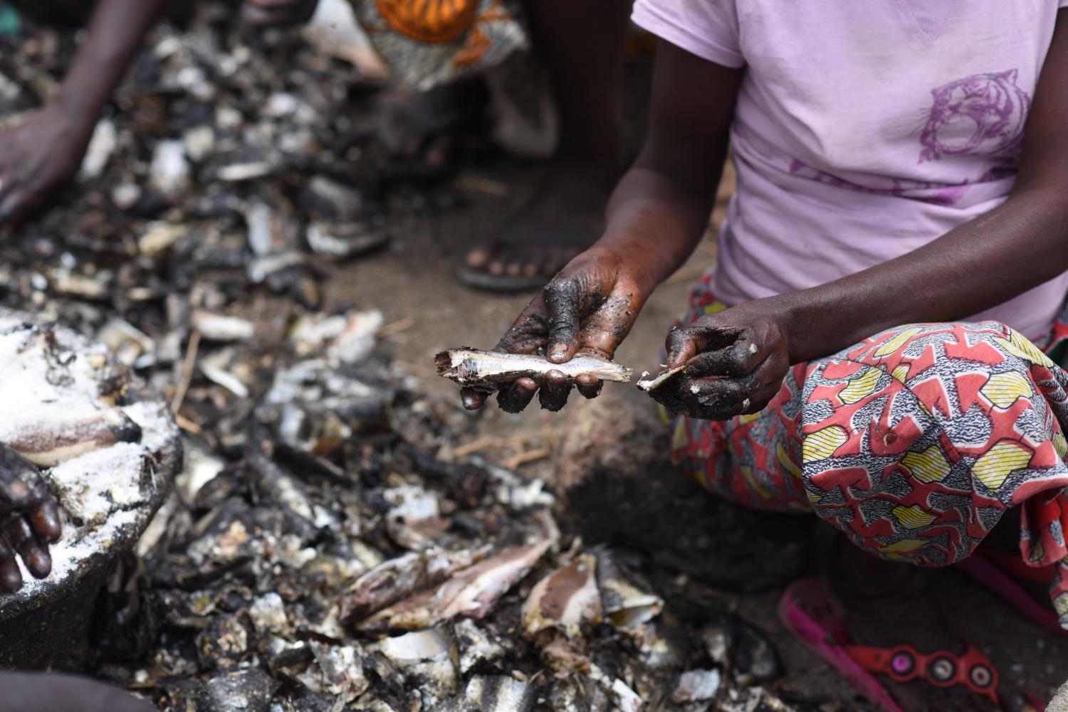 Women apply salt to dried fish at an artisanal fish processing facility in the Senegalese coastal town of Joal-Fadiouth, April 10, 2018. Picture taken April 10, 2018.   To match Special Report OCEANS-TIDE/SARDINELLA   REUTERS/Sylvain Cherkaoui - RC1E49820D10