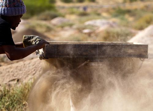 A member of the Batho Pele cooperative of artisanal miners sifts through sand and rocks searching for diamonds in Kimberley, South Africa, October 22, 2019. Picture taken October 22, 2019. REUTERS/Sumaya Hisham - RC2V8D9IT4DR