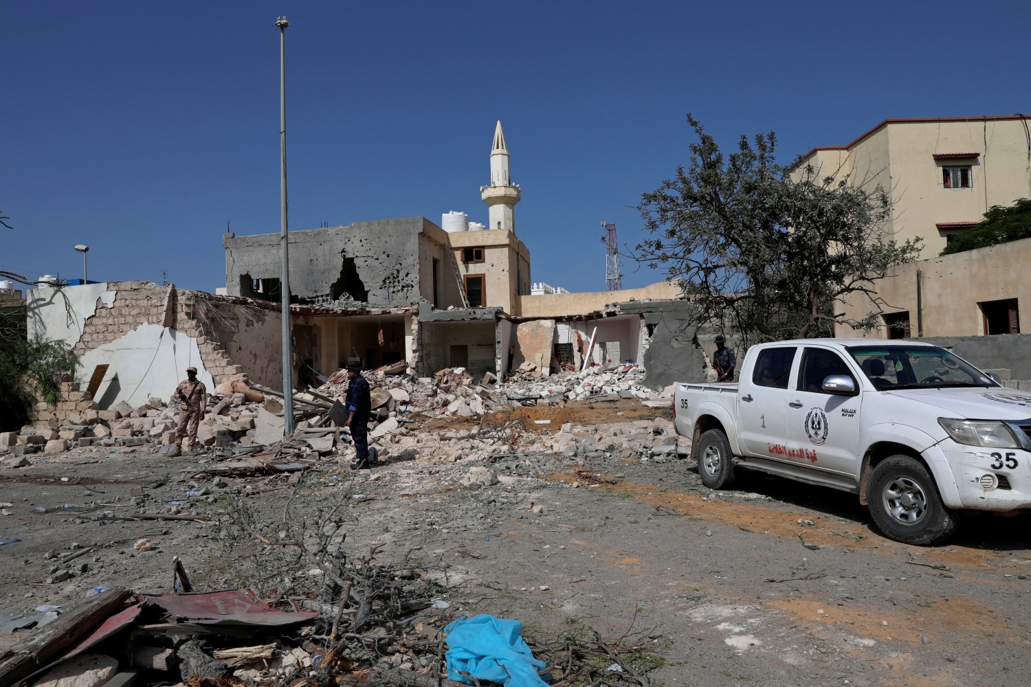 Security members inspect the site of an overnight air strike, which hit a residential district in Tripoli, Libya October 14, 2019.  REUTERS/Ismail Zitouny
