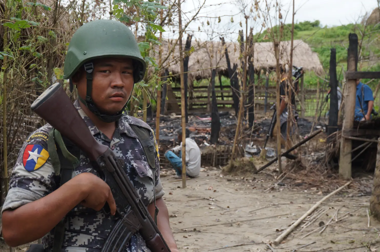 A Myanmar border guard police officer stands guard in front of the remains of a house burned down in a clash between suspected militants and security forces in Tin May village,  Buthidaung township, northern Rakhine state, Myanmar July 14, 2017. Picture taken July 14, 2017. REUTERS/Simon Lewis - RC17166738A0