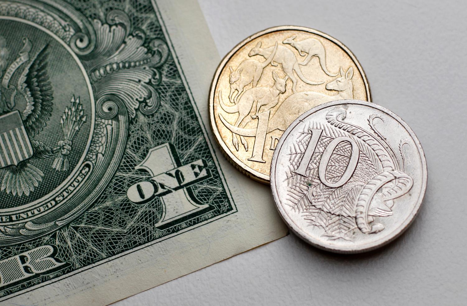 One dollar and 10 cents in Australian currency sit atop a U.S. one dollar note in this photo illustration taken in Sydney July 27, 2011. Australian consumer prices rose by more than expected last quarter while underlying inflation proved alarmingly high, reviving pressure for an increase in interest rates and lifting the local dollar to a 29-year peak. REUTERS/Tim Wimborne (AUSTRALIA - Tags: BUSINESS) - GM1E77R10FA01