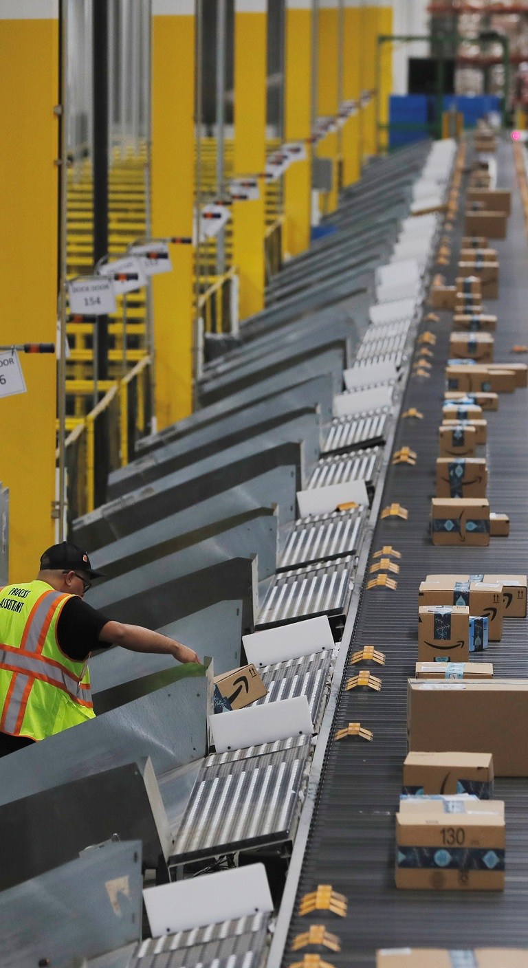 Amazon packages are pushed onto ramps leading to delivery trucks by a robotic system as they travel on conveyor belts inside of an Amazon fulfillment center on Cyber Monday in Robbinsville, New Jersey, U.S., December 2, 2019. REUTERS/Lucas Jackson