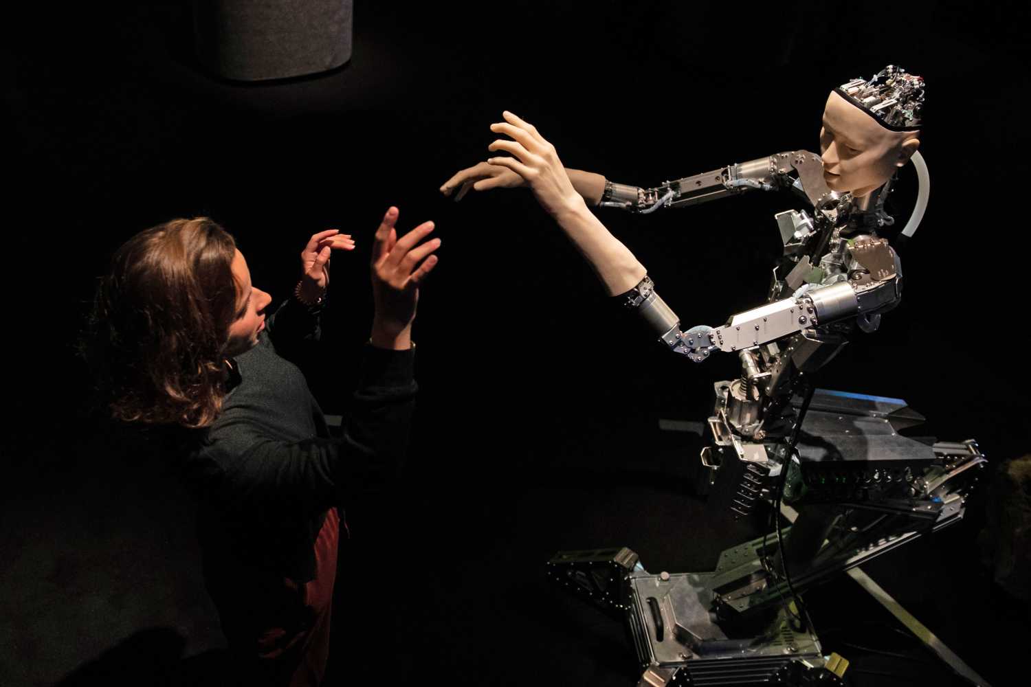 A women interacts with 'Alter', a machine body with a human like face and hands who learns through interplaying with the surrounding world. Alter was created by roboticist Hiroshi Ishiguro and is on display at the 'AI: More Than Human' exhibition at the Barbican Centre in London. The major new exhibition explores the relationship between humans and artificial intelligence.