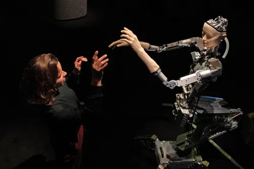 A women interacts with 'Alter', a machine body with a human like face and hands who learns through interplaying with the surrounding world. Alter was created by roboticist Hiroshi Ishiguro and is on display at the 'AI: More Than Human' exhibition at the Barbican Centre in London. The major new exhibition explores the relationship between humans and artificial intelligence.