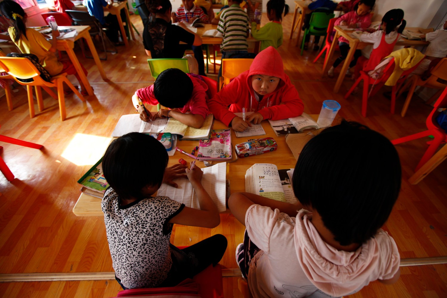 Children of migrant workers attend a class in a container used as a classroom during an after-school programme initiated by Compassion for Migrant Children (CMC) in Beijing May 25, 2011. According to their official website, CMC is a nonprofit organization founded in early 2006 to help China's urban migrant children, primarily through offering social and educational programs.    REUTERS/Petar Kujundzic (CHINA - Tags: EDUCATION)