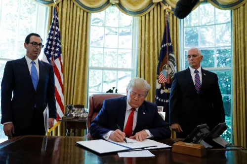 U.S.  President Donald Trump signs an executive order imposing fresh sanctions on Iran as Treasury Secretary Steven Mnuchin and Vice President Mike Pence look on in the Oval Office of the White House in Washington, U.S., June 24, 2019. REUTERS/Carlos Barria