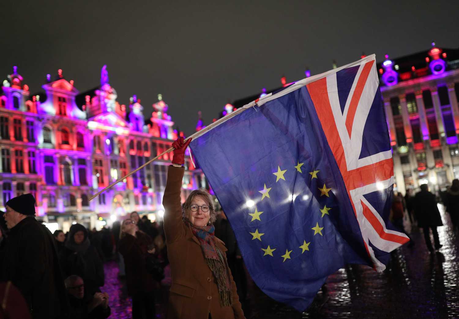 Deirdre Thomas, a resident of Belguim, waving an EU flag and a Union jack in Grand Place in Brussels, Belgium, during a celebration and farewell to the UK on the eve of Brexit.