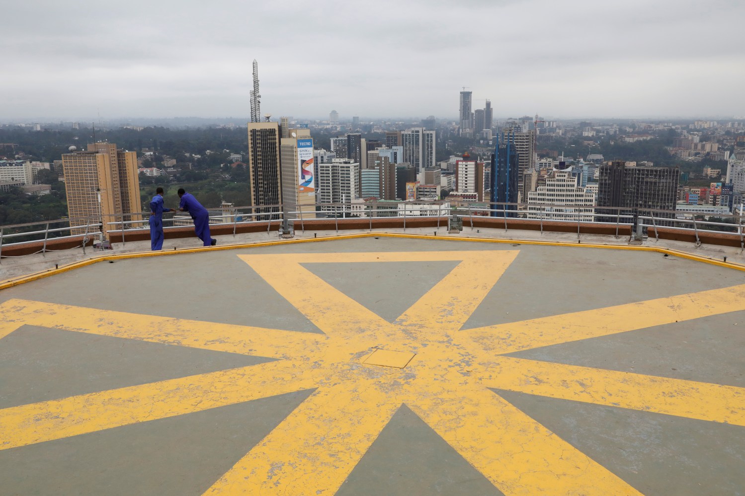 Men look at the Nairobi skyline from observation point on the top of the Kenyatta International Convention Centre in Nairobi, Kenya, June 21, 2019. REUTERS/Baz Ratner - RC1D930C2460
