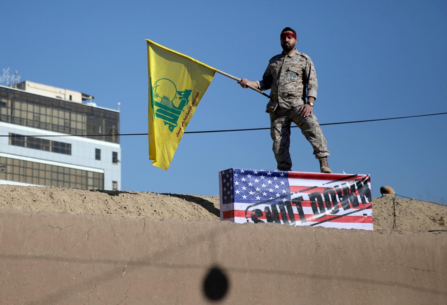 An Iranian guard holds a Hezbollah flag during a funeral procession and burial for Iranian Major-General Qassem Soleimani, head of the elite Quds Force, who was killed in an air strike at Baghdad airport, at his hometown in Kerman, Iran January 7, 2020. Mehdi Bolourian/Fars News Agency/WANA (West Asia News Agency) via REUTERS ATTENTION EDITORS - THIS IMAGE HAS BEEN SUPPLIED BY A THIRD PARTY