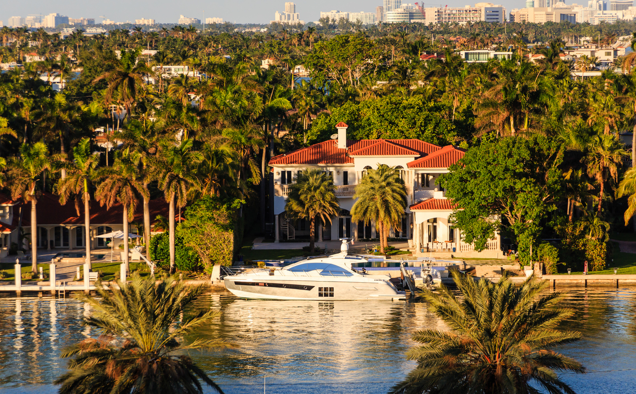 A Luxury White Yacht by a Miami Mansion