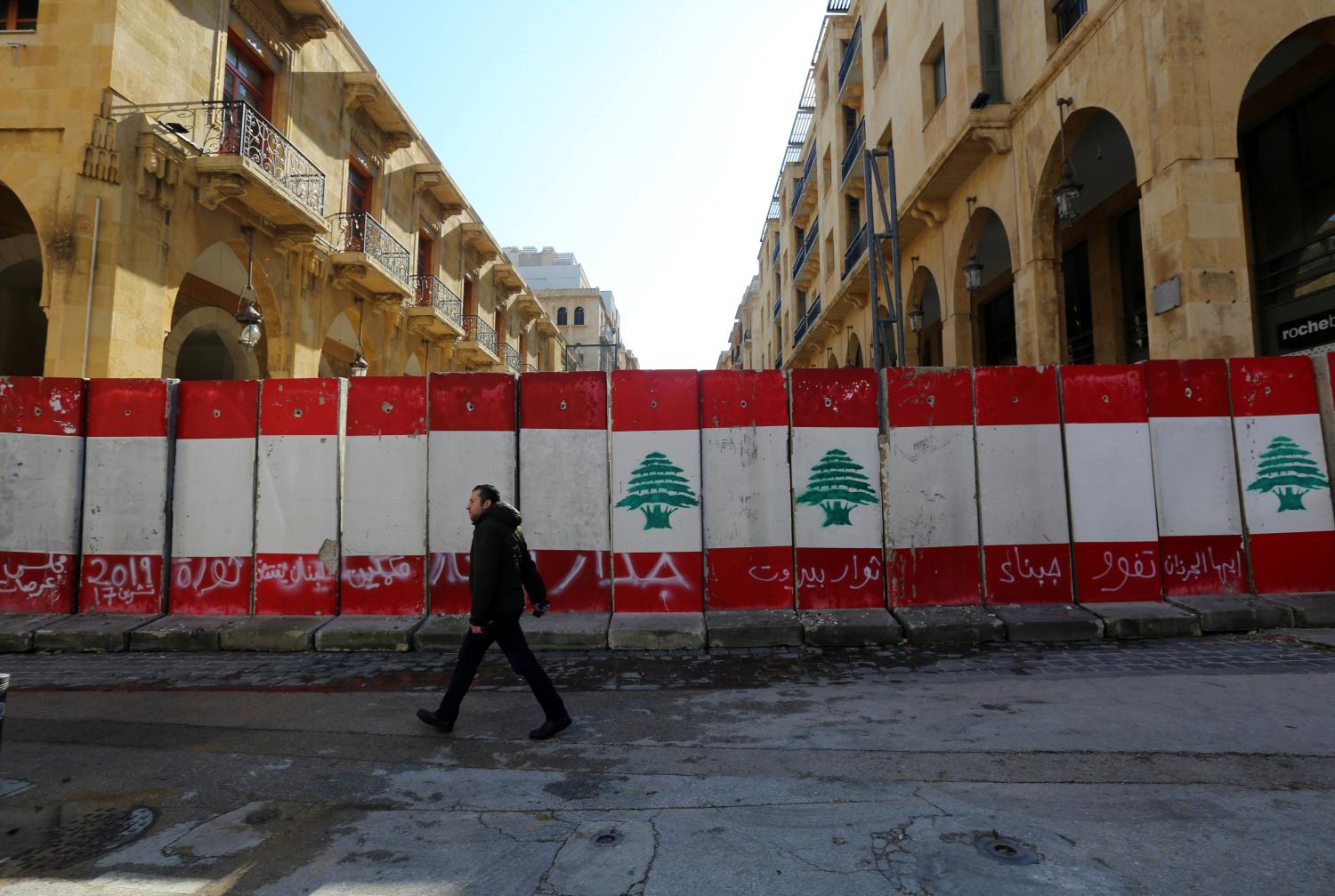 A man walks past concrete barriers erected by authorities to block a street leading to the parliament building in Beirut, Lebanon January 24, 2020. REUTERS/Aziz Taher