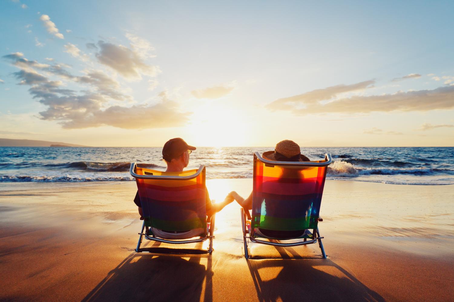 retired couple sits on the beach