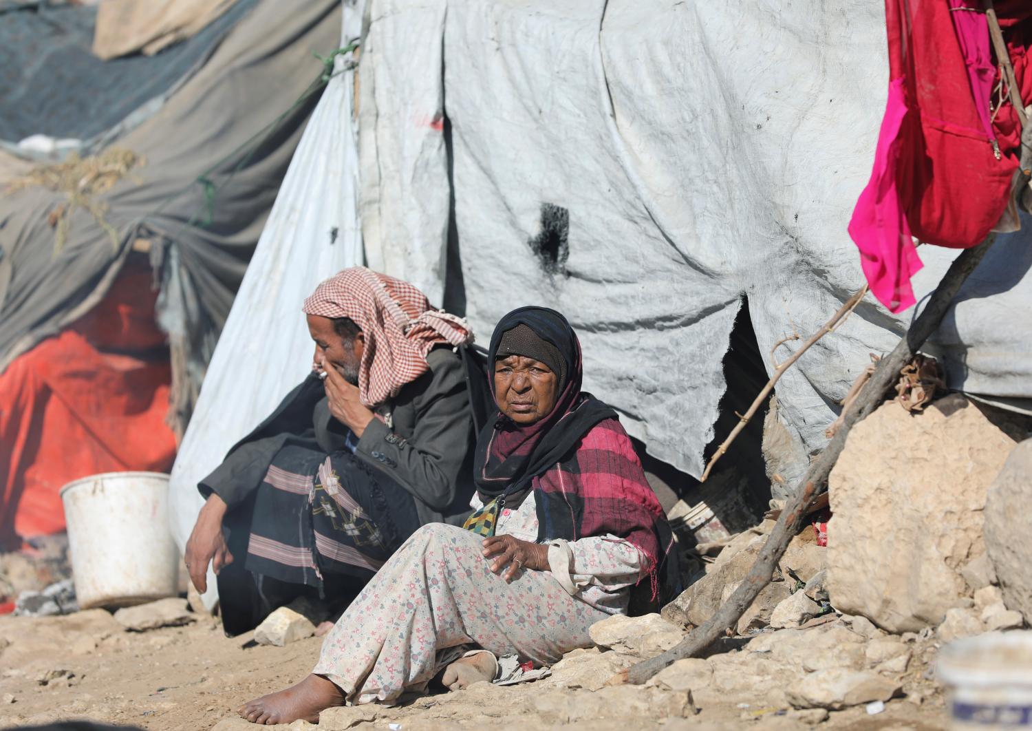 People sit in the sun on a cold winter day at a camp for internally displaced people in Khamir of the northwestern province of Amran, Yemen December 16, 2019. Picture taken December 16, 2019. REUTERS/Khaled Abdullah