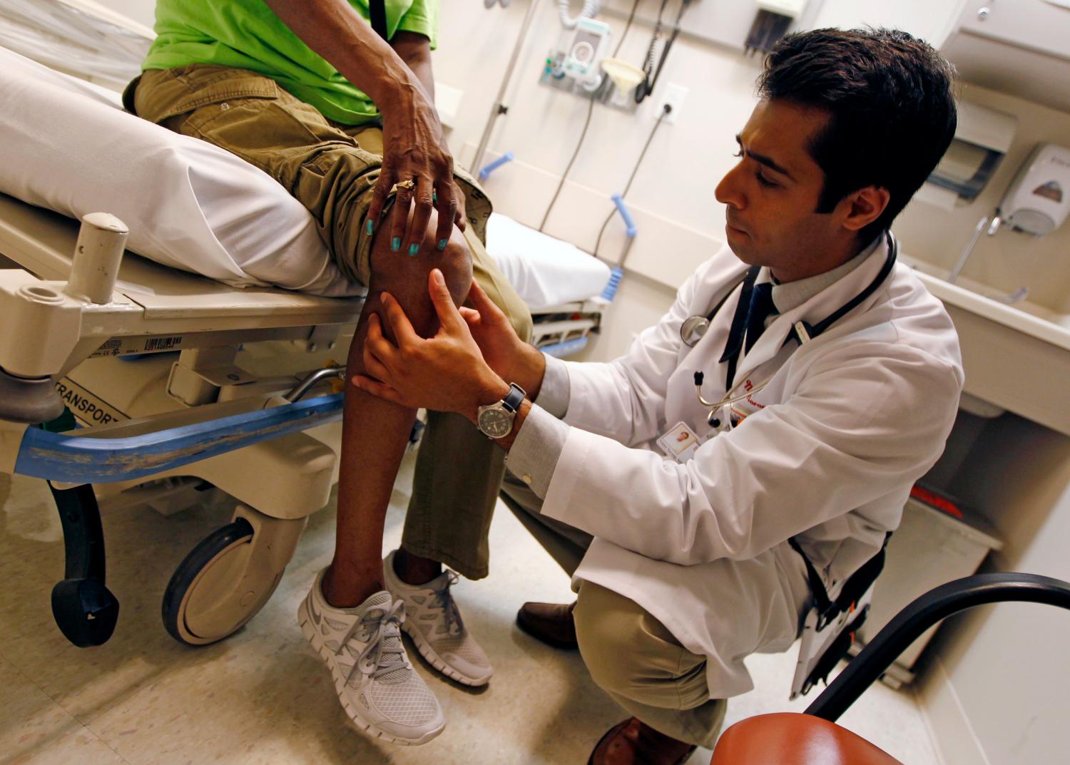 Patient Sharon Dawson Coates (L) has her knee examined by Dr. Nikhil Narang at University of Chicago Medicine Urgent Care Clinic in Chicago June 28, 2012.  REUTERS/Jim Young (UNITED STATES - Tags: EDUCATION HEALTH)