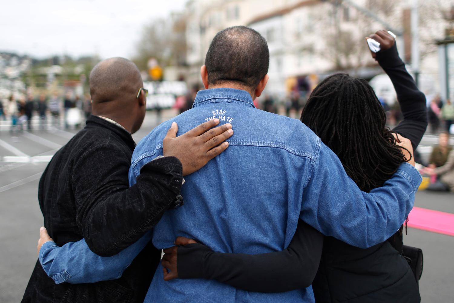 Three protesters embrace each other during a peaceful protest against police violence organized by the San Francisco LGBT Community Center in San Francisco, California December 24, 2014. An 18-year old black teen was fatally shot by police at a gas station late on Tuesday in a St. Louis suburb near where unarmed teen Michael Brown was killed by a white officer in August. REUTERS/Stephen Lam  (UNITED STATES - Tags: CRIME LAW CIVIL UNREST)