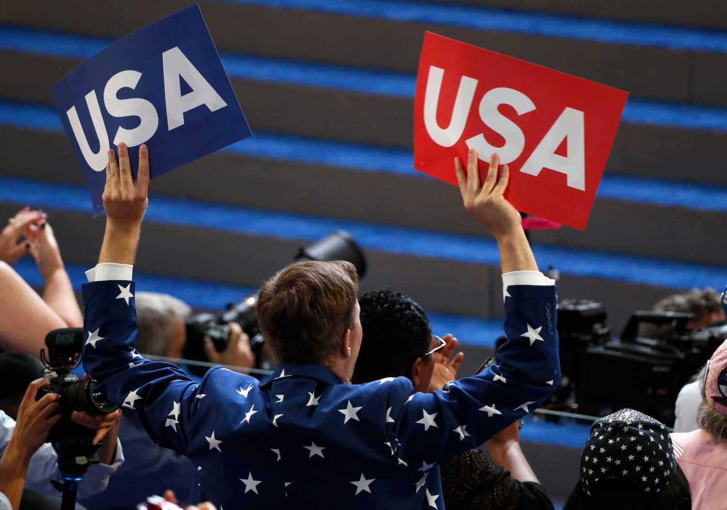 A delegate waves USA signs on the final night of the Democratic National Convention in Philadelphia, Pennsylvania, U.S. July 28, 2016. REUTERS/Mike Segar