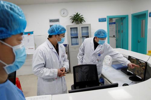 FILE PHOTO: Doctors look at a screen that shows the ward where patients who are infected with the coronavirus are treated at the First People's Hospital in Yueyang, Hunan Province, near the border to Hubei Province, which is under partial lockdown after an outbreak of a new coronavirus, in China January 28, 2020.  REUTERS/Thomas Peter/File Photo