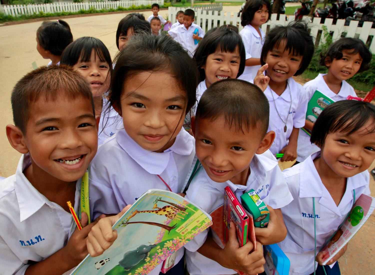 Students hold their textbooks and stationeries during recess in a primary school in northeastern Khon Kaen province May 24, 2011. Overcrowding in classrooms is just one of the problems dogging Thailand's education system, where an inward-looking curriculum emphasises rote-learning and basic literacy. Critics say that without an overhaul to bring the system into the 21st century, Thailand will lose out in the race with Asian rivals for foreign investment. Picture taken May 24, 2011. To match Analysis THAILAND-EDUCATION   REUTERS/Sukree Sukplang (THAILAND - Tags: EDUCATION)