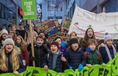 Children march through a shopping centre in Cambridge during a YouthStrike4Climate march.