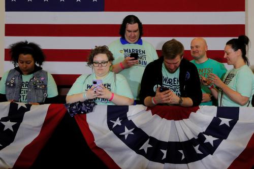 Supporters of Democratic 2020 U.S. presidential candidate and U.S. Senator Elizabeth Warren (D-MA) look at their mobile phones before she speaks at her Iowa Caucus rally in Des Moines, Iowa, U.S., February 3, 2020. Picture taken February 3, 2020. REUTERS/Brian Snyder