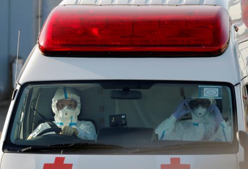 FILE PHOTO: Workers wearing protective suits drive an ambulance near the cruise ship Diamond Princess, as they prepare to transfer passengers tested positive for the novel coronavirus, at Daikoku Pier Cruise Terminal in Yokohama, south of Tokyo, Japan February 10, 2020. REUTERS/Kim Kyung-Hoon/File Photo