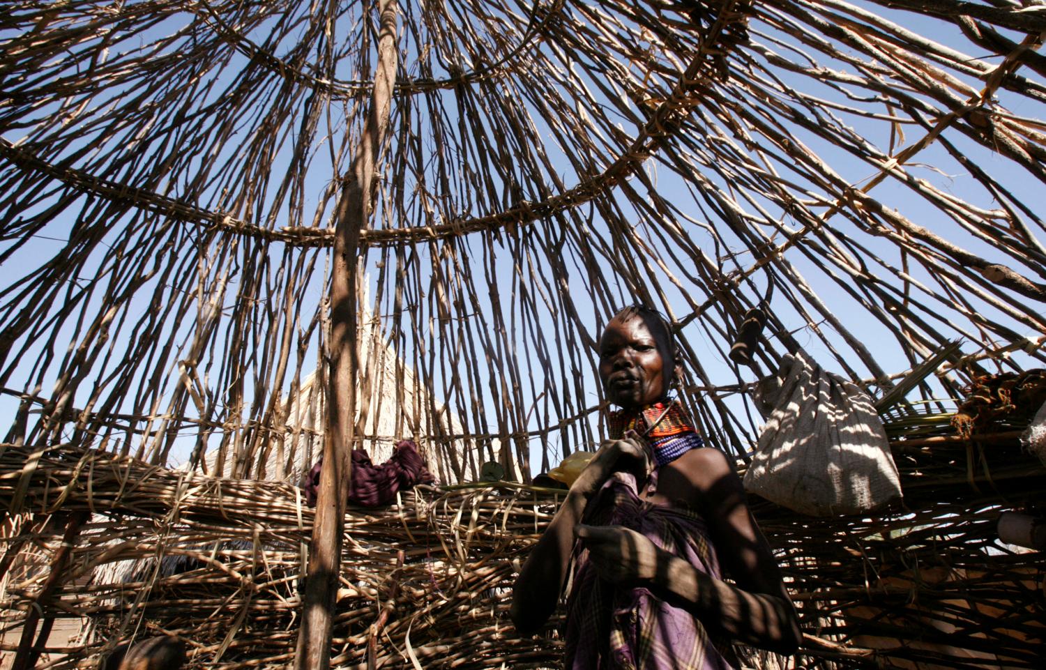 A Turkana woman walks inside her makeshift house in Lobei village of Turkana district in northwest Kenya, October 2, 2009. The Turkana people are among the worst affected by the drought since they have also lost the ability to migrate as a result of conflict with the neighbouring communities leading to livestock deaths as a result of extreme heat, lack water and lack of pasture. REUTERS/Thomas Mukoya (KENYA SOCIETY ENVIRONMENT CONFLICT)