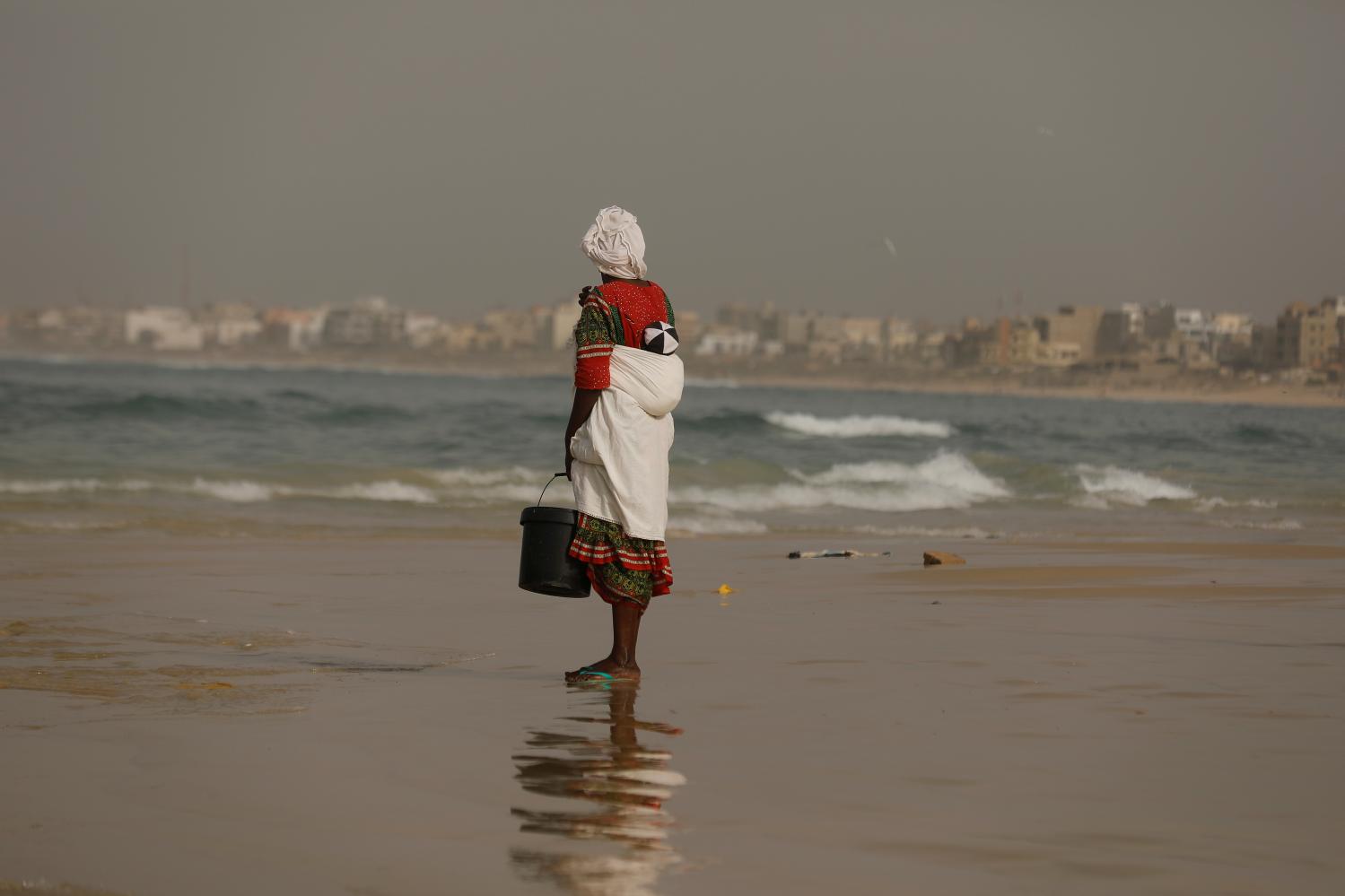 A fish seller waits to buy fresh product from fishermen at the port of Yoff in Dakar, Senegal February 14, 2019. REUTERS/Zohra Bensemra