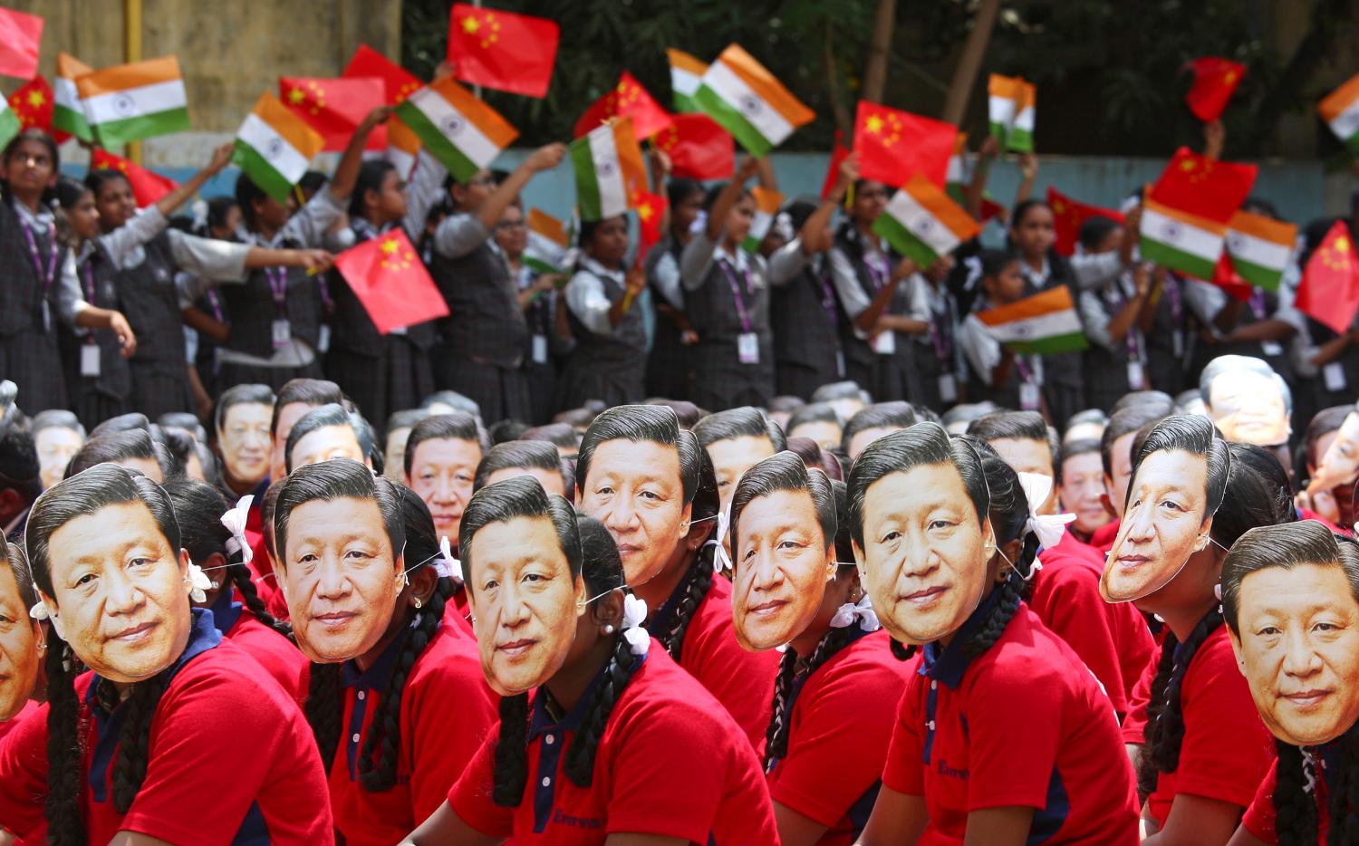 Students wear masks of China's President Xi Jinping as other waves national flags of India and China, ahead of the informal summit with India’s Prime Minister Narendra Modi, at a school in Chennai, India, October 10, 2019. REUTERS/P. Ravikumar     TPX IMAGES OF THE DAY