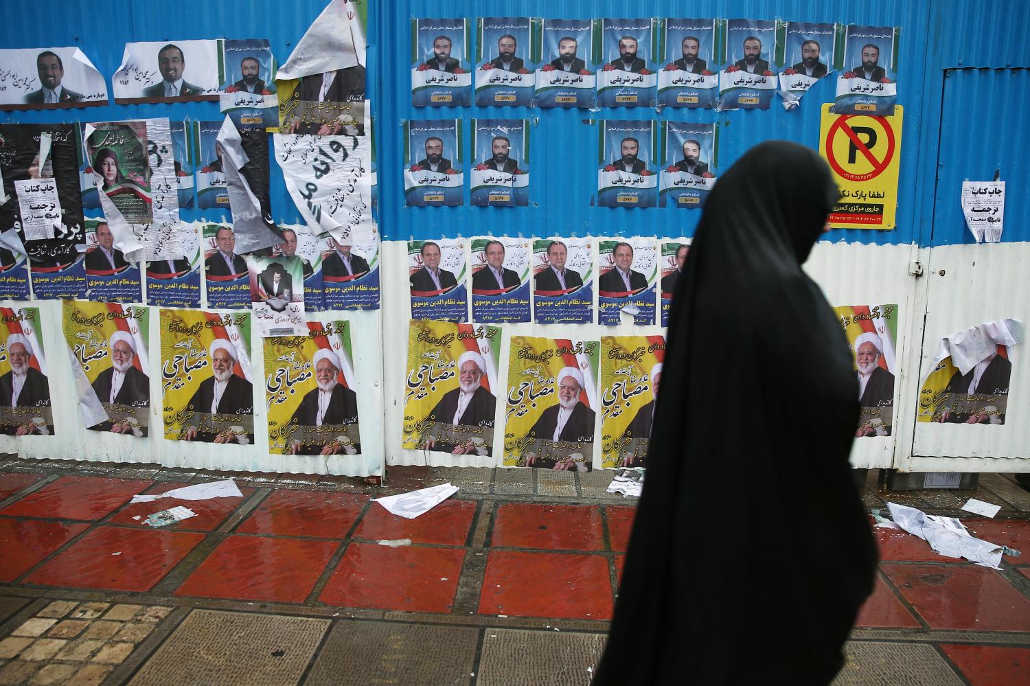 A woman walks past parliamentary election campaign posters at the end of the parliamentary election day in Tehran, Iran February 20, 2020. WANA (West Asia News Agency)/Nazanin Tabatabaee via REUTERS ATTENTION EDITORS - THIS IMAGE HAS BEEN SUPPLIED BY A THIRD PARTY.