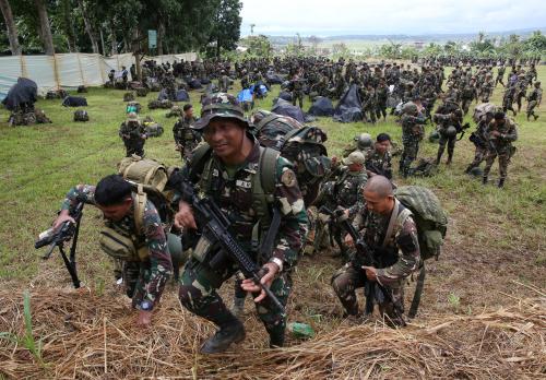 Government troops with their belongings walk towards waiting vehicles during a send-off ceremony ending their combat duty against pro-Islamic State militant groups inside military headquarters in Marawi city,  Philippines October 25, 2017.       REUTERS/Romeo Ranoco