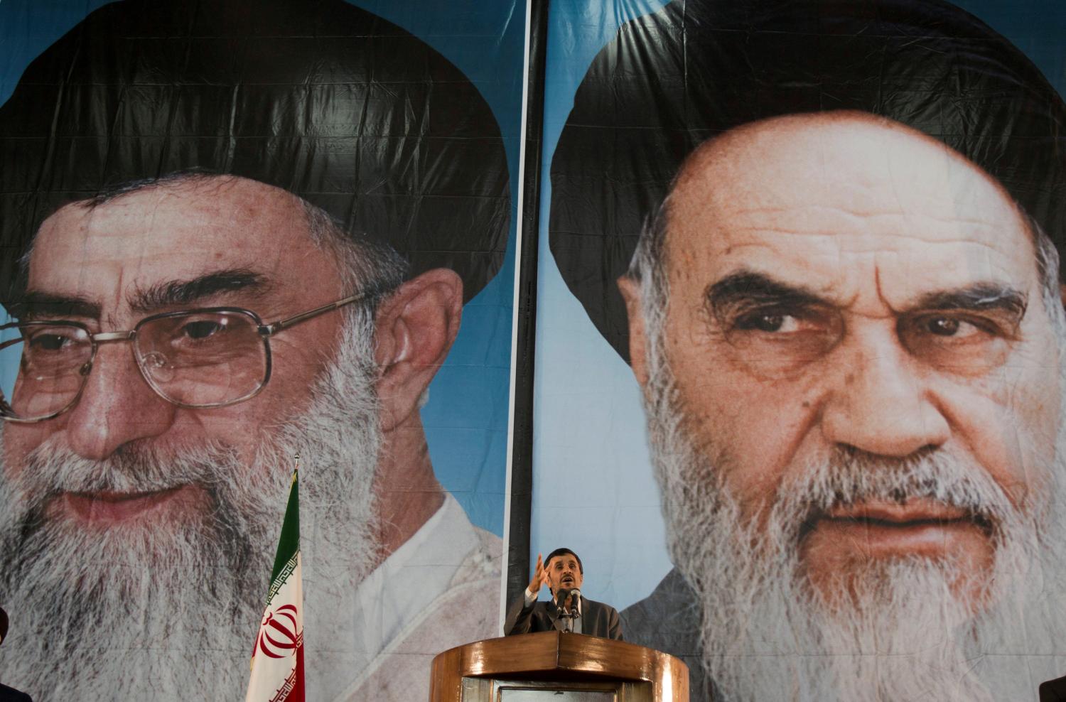 Iranian President Mahmoud Ahmadinejad stands under pictures of Iran's Supreme Leader Ayatollah Ali Khamenei (L) and Iran's late leader Ayatollah Ruhollah Khomeini while speaking during a ceremony to mark Khomeini's death anniversary at his tomb at Tehran's Behesht-Zahra cemetery June 3, 2011. REUTERS/Morteza Nikoubazl/File Photo