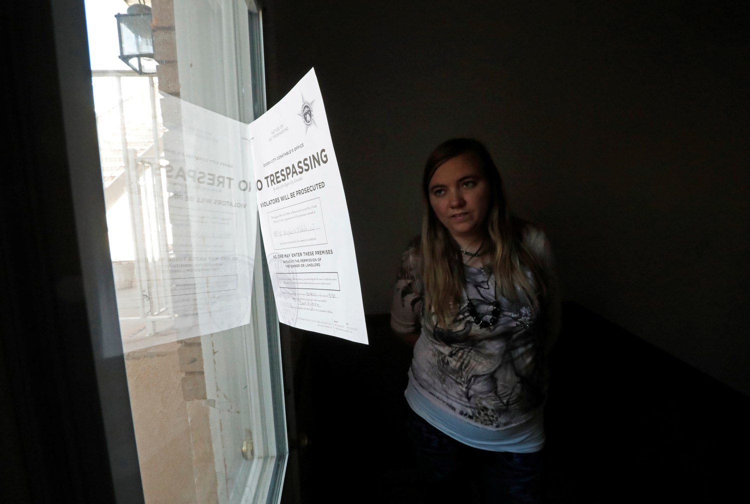 Briell Decker, the 65th wife of jailed Fundamentalist Church of Jesus Christ of Latter-Day Saints (FLDS Church) polygamist prophet leader Warren Jeffs, looks at an eviction notice on the window at his compound, where he lived for several years, in Hildale, Utah, U.S., May 3, 2017. She is in the process of purchasing the compound. Picture taken May 3, 2017.  REUTERS/George Frey