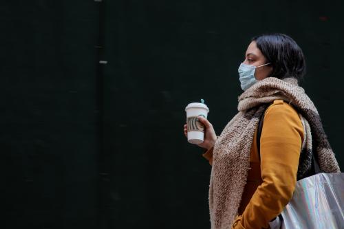 A woman wears a mask on Wall St. near the New York Stock Exchange (NYSE) in New York, U.S., March 2, 2020. REUTERS/Brendan McDermid