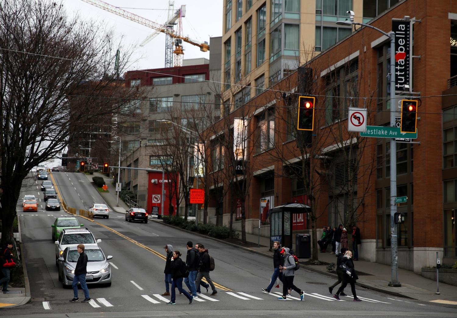 People cross Westlake Avenue during Friday rush hour in the South Lake Union neighborhood, home to Amazon, after the company asked employees to work from home for the rest of the month if possible in Seattle, Washington, U.S. March 6, 2020. REUTERS/Lindsey Wasson 