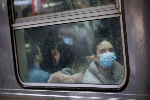 A woman wears a face mask on the subway as the coronavirus outbreak continued in Manhattan, New York City, New York, U.S., March 13, 2020. REUTERS/Andrew Kelly