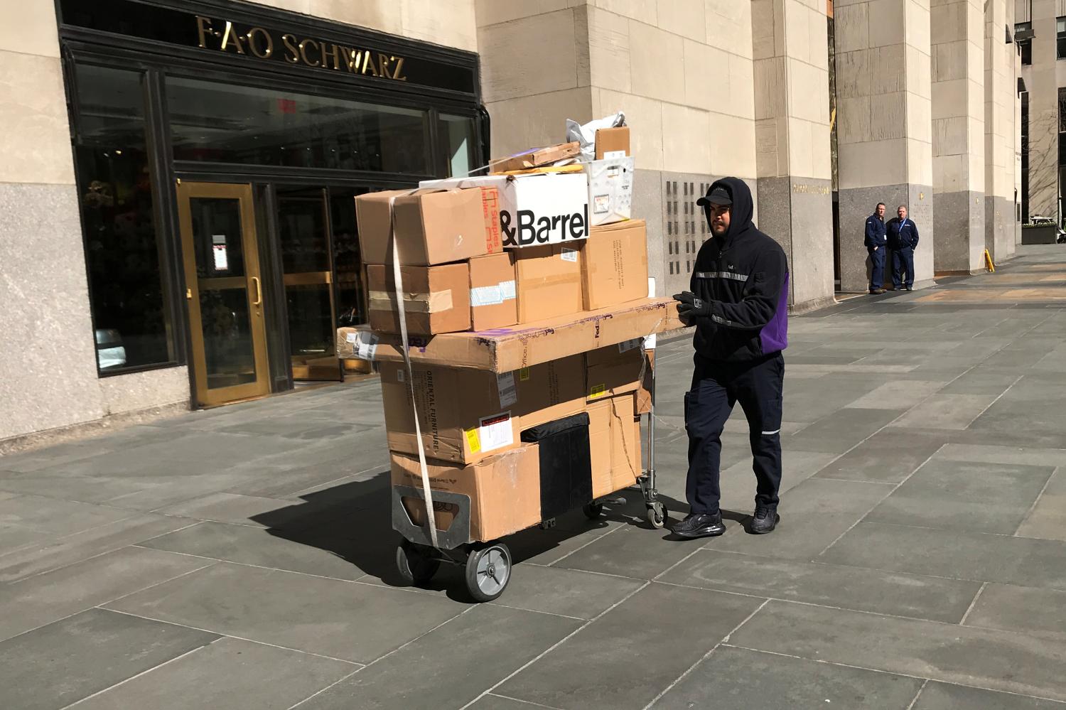 A worker delivers packages following the outbreak of coronavirus disease (COVID-19), in the Manhattan borough of New York City, New York, U.S., March 16, 2020. REUTERS/Carlo Allegri