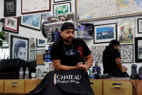 Barber Adan Covarrubias, 28, stands behind his chair, prior to California's Governor Gavin Newsom’s effective immediately statewide "stay at home order", in the face of the fast-spreading pandemic coronavirus (COVID-19), at the Chateau Barber Shop in Napa, California, U.S. March 19, 2020. Picture taken March 19, 2020. REUTERS/Shannon Stapleton