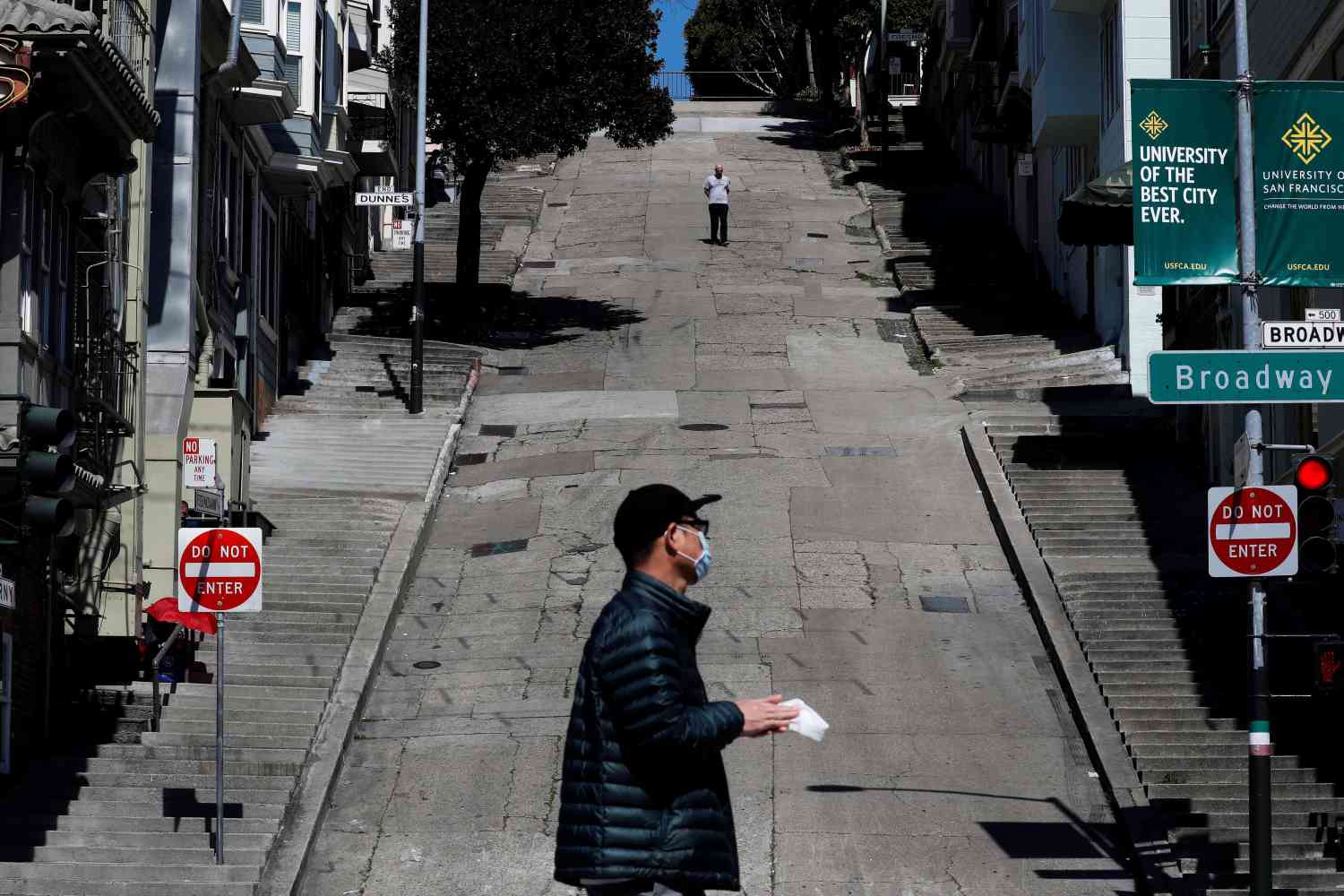 People walk on the streets, a day after California's Governor Gavin Newsom implemented a statewide "stay at home order" directing the state's nearly 40 million residents to stay in their homes for the foreseeable future in the face of the fast-spreading coronavirus disease (COVID-19), in San Francisco, California, U.S. March 20, 2020. REUTERS/Shannon Stapleton     TPX IMAGES OF THE DAY