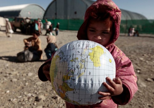A girl carries a globe she received from a free clinic set up by the Afghan national army and Task Force Denali 1/40 CAV at FOB Clark in Khowst province December 15, 2009. Every Tuesday, the clinic receives children from neighbouring villages for a medical check and supplies them with clothes and school stationery.     REUTERS/Zohra Bensemra (AFGHANISTAN - Tags: POLITICS MILITARY SOCIETY HEALTH)