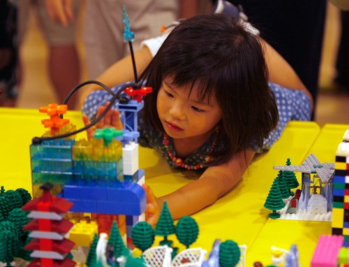 A girl gives a last touch to her Lego work on Dream City which was built by about 100,000 pieces of Lego blocks in Tokyo August 16, 2009. About 1,000 children and their parents participated in the Japan's largest Lego event on Sunday.   REUTERS/Kim Kyung-Hoon (JAPAN SOCIETY)